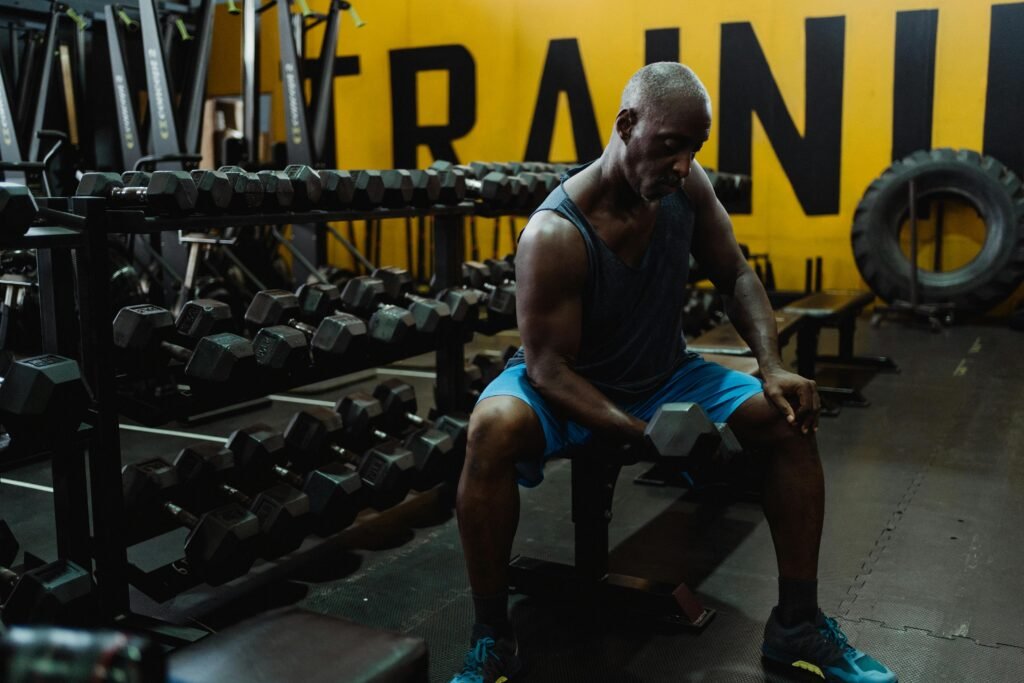 man curling dumbbell in commercial gym
